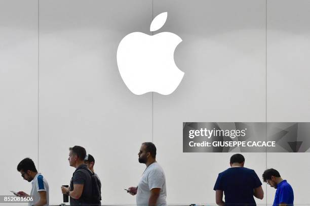 Customers stand in line to purchase the new Apple iPhone 8 at Dubai Mall Apple Store in Dubai, on September 23, 2017. The new Apple iPhone 8 and 8...