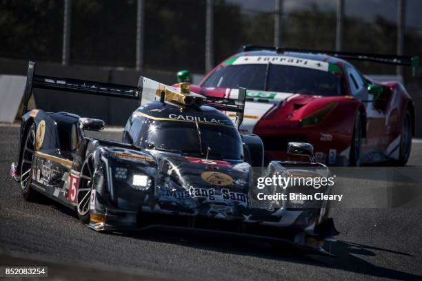 The Cadillac DPi of Joao Barbosa, of Portugal, and Christian Fittipaldi, of Brazil, races on the track during practice for the IMSA WeatherTech...