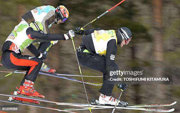 Swiss skier Michael Schmid leads ahead of Austria's Thomas Zangerl and Italy's Karl Heinz Molling during the 1/8 round of the men's ski cross in the...