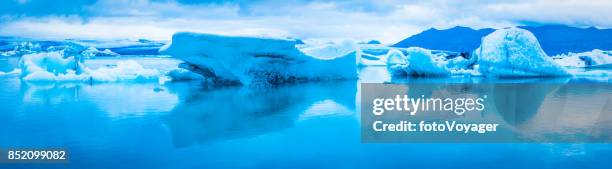 blue icebergs reflecting in tranquil arctic ocean lagoon panorama iceland - oceano-ártico imagens e fotografias de stock