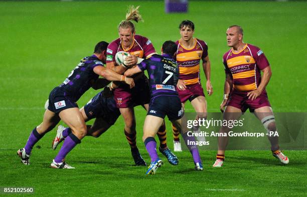 Huddersfield Giants' Eorl Crabtree is tackled by Wigan Warriors' Ben Flower and Matthew Smith during the Super League Elimination Play Off at the...