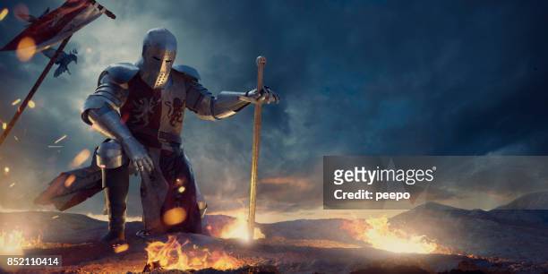 knight in amour kneeling with sword on hilltop near fire - cavaleiro imagens e fotografias de stock