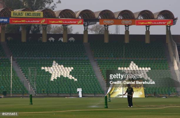 Lone ground keeper waters the pitch as the Gaddafi Stadium stands empty on March 4, 2009 in Lahore, Pakistan. Lahore recovers from Tuesday's...