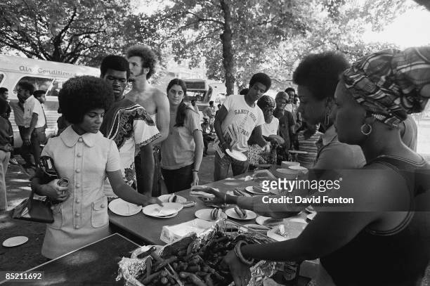 Members of the Black Panther Party stand behind tables and distribute free hot dogs to the public, New Haven, Connecticut, late 1960s or early 1970s.