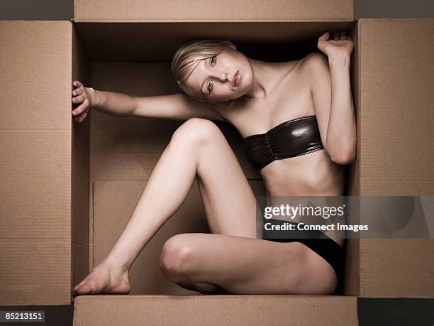 young woman in cardboard box - pin up stock-fotos und bilder