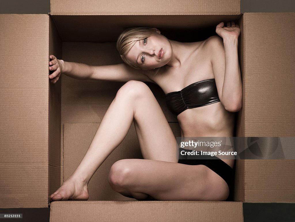 Young woman in cardboard box