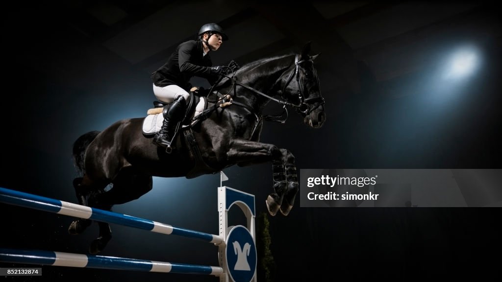 Zwarte paard springen spoor met zijn ruiter