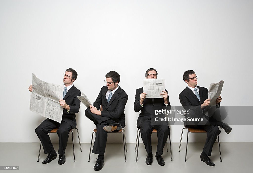 Businessmen reading newspaper