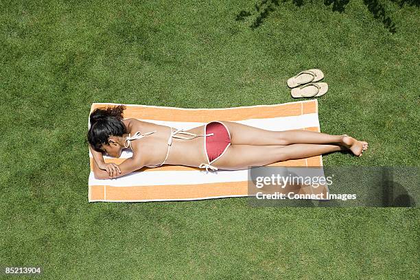 young woman sunbathing - allongé sur le devant photos et images de collection