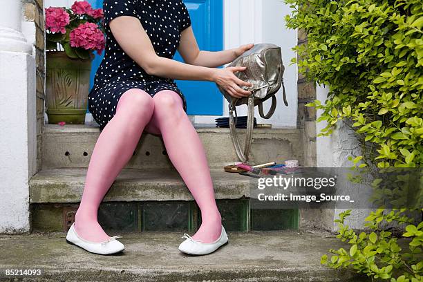 woman emptying handbag on doorstep - handbag stock pictures, royalty-free photos & images