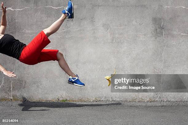 woman falling on a banana skin - banana woman stock pictures, royalty-free photos & images