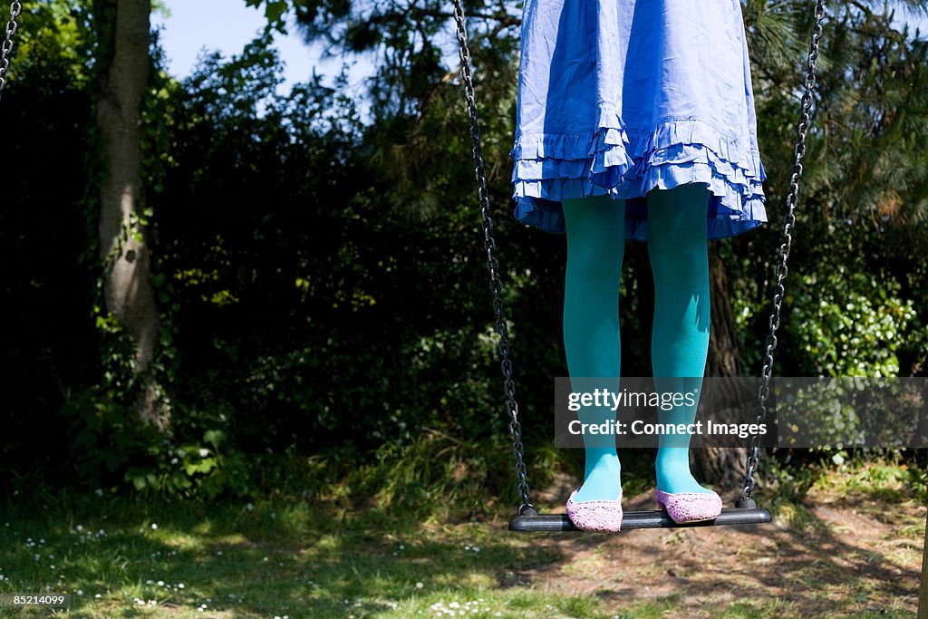 Woman standing on a swing