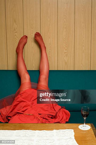 woman lying upside down on a sofa - women wearing nylons photos et images de collection