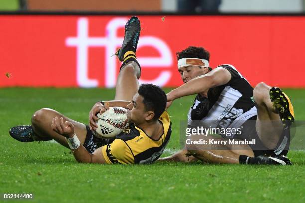 Stephen Perofeta of Taranaki gathers a loose ball under pressure from Jonah Lowe of Hawke's Bay during the round six Mitre 10 Cup match between...