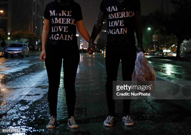 Two protesters hold hands in the middle of the street as they block oncoming traffic for a larger group of protesters at the justice building. Police...