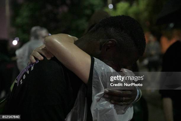 Trenton Meyer hugs his sister, Melanie Meyer as rain falls outside during Monday night's protest. Meyer said she hadn't seen her brother in three...