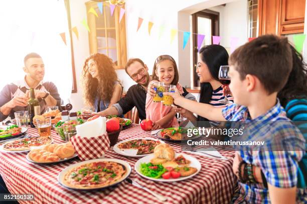 familia la cena en casa - cena con amigos fotografías e imágenes de stock