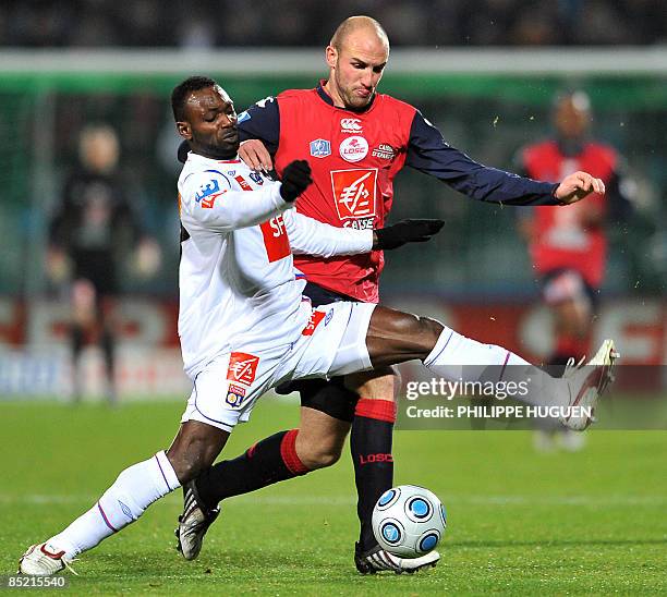 Lille's Slovakian forward Robert Vittek vies with Lyon's defender John Mensah during their French Cup football match Lille vs. Lyon on March 4, 2009...