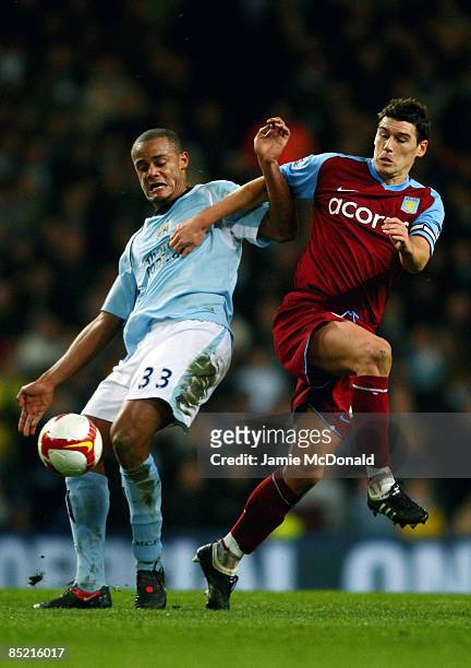 Gareth Barry of Aston Villa is tackled by Vincent Kompany of Manchester City during the FA Barclays Premier League match between Manchester City and...