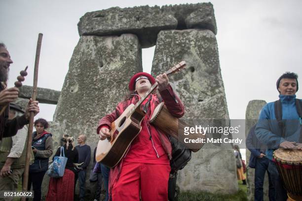 Man plays a guitar as druids, pagans and revellers gather at Stonehenge, hoping to see the sun rise, as they take part in a autumn equinox...