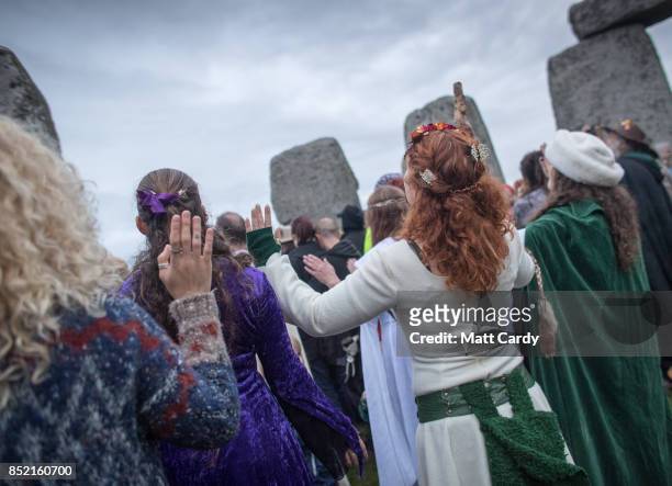 Druids, pagans and revellers gather in the centre at Stonehenge, hoping to see the sun rise, as they take part in a autumn equinox celebrations at...