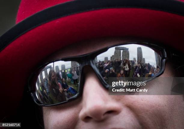 Druids, pagans and revellers are reflected in a man's sunglasses as they gather at Stonehenge, hoping to see the sun rise, as they take part in a...