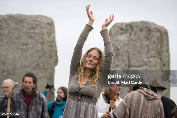 Woman dances as druids, pagans and revellers gather at Stonehenge, hoping to see the sun rise, as they take part in a autumn equinox celebration at...