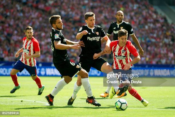 Luciano Vietto of Club Atletico de Madrid tries to beat Daniel Carrico of Sevilla FC during the La Liga match between Atletico Madrid and Sevilla at...