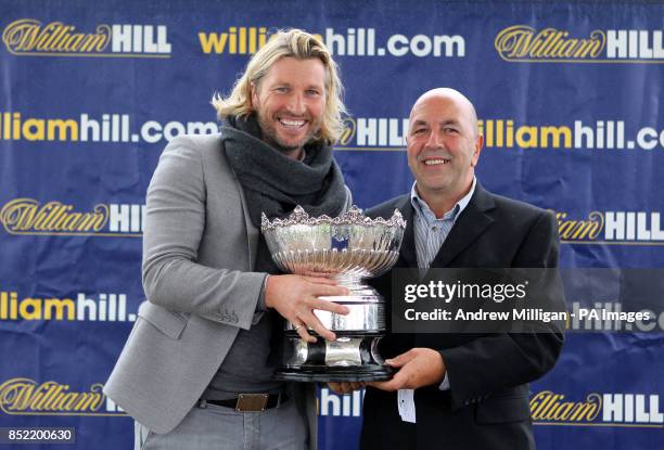 Robbie Savage hand out the Kilkerran Cup to owner Ronnie Devlin after the horse Hi There won The William Hill Download The App Handicap Stakes during...