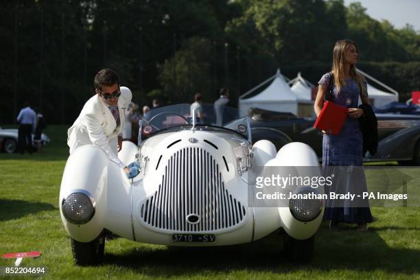 The owner of a 1931 Alfa Romeo 6C 1750 Gran Sport Aprile Spider Corsa gives it a polish while putting the vehicle on display as part of the opening...