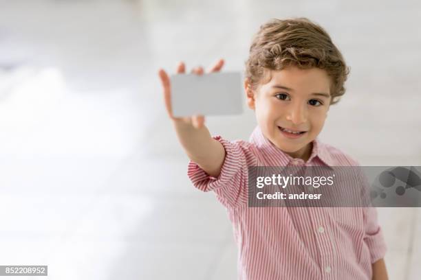 happy boy shopping at the mall holding a loyalty card - loyalty cards stock pictures, royalty-free photos & images