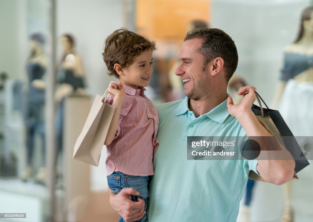 Lycklig far och son på shopping center