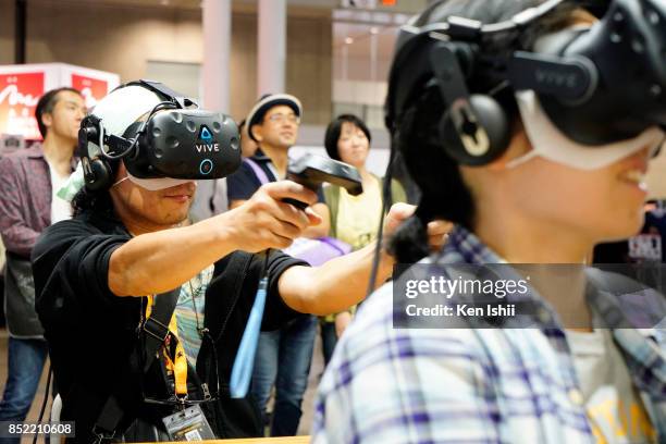 Visitors wearing VR headset play the game at the HTC Corp. Booth during the Tokyo Game Show 2017 at Makuhari Messe on September 23, 2017 in Chiba,...