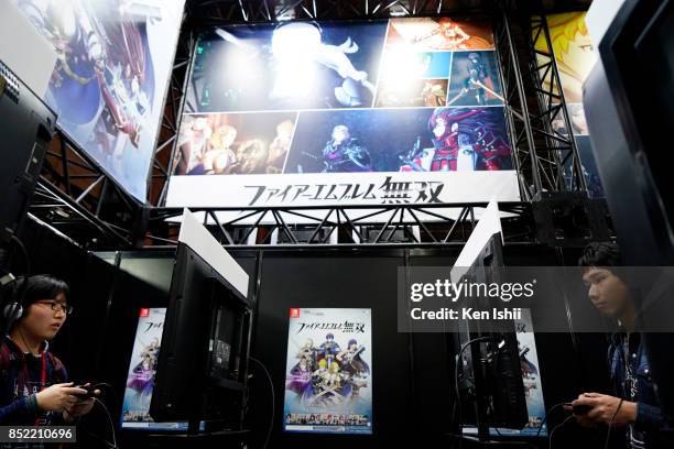 Visitors play video game on PlayStation 4 game console at the Koei Tecmo Holdings Co. Booth during the Tokyo Game Show 2017 at Makuhari Messe on...