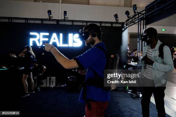 Visitors wearing a VR headset play the game in the Shenzhen Realis Multimedia Technology Co.,Ltd. Booth during the Tokyo Game Show 2017 at Makuhari...