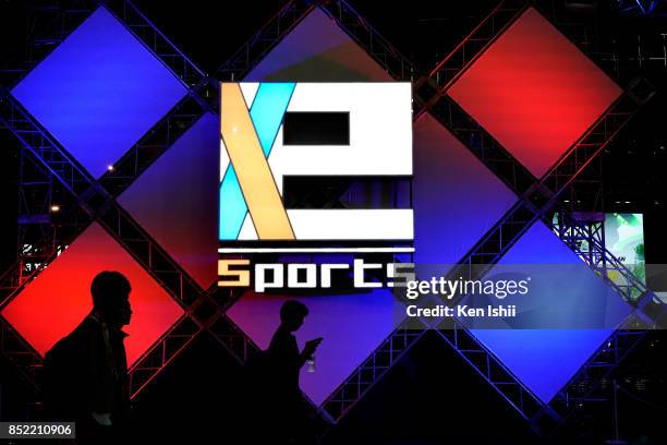 People walk past e-Sports logo during the Tokyo Game Show 2017 at Makuhari Messe on September 23, 2017 in Chiba, Japan.