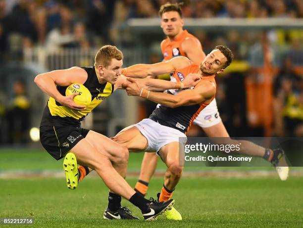 Jacob Townsend of the Tigers fends off a tackle by Brett Deledio of the Giants during the Second AFL Preliminary Final match between the Richmond...