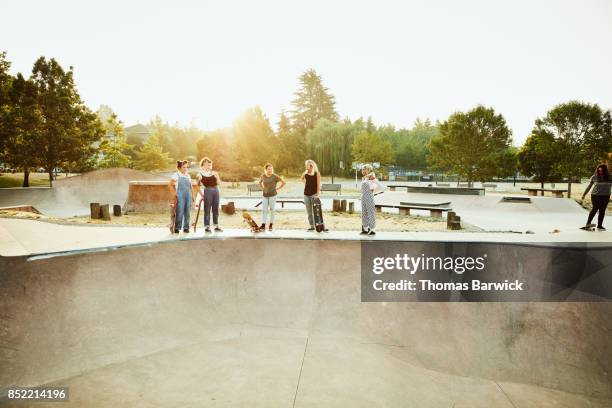 female skateboarders hanging together at skate park on summer morning - skateboard park stock pictures, royalty-free photos & images