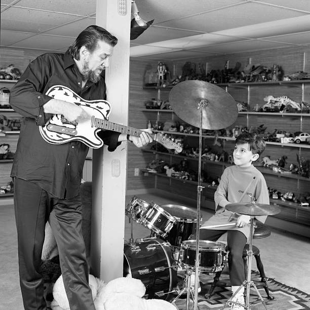 Country singer and songwriter Waylon Jennings and son Shooter Jennings jam together at home on December 9, 1987 in Nashville, Tennessee.