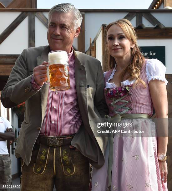 Carlo Ancelotti , Italian head coach of German first division Bundesliga football club FC Bayern Munich, holds a beer mug as he poses with his wife...