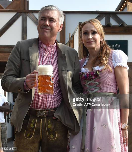 Carlo Ancelotti , Italian head coach of German first division Bundesliga football club FC Bayern Munich, holds a beer mug as he poses with his wife...