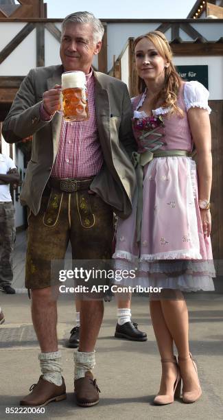 Carlo Ancelotti , Italian head coach of German first division Bundesliga football club FC Bayern Munich, holds a beer mug as he poses with his wife...