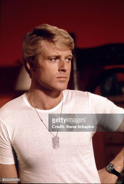 View of American actor Robert Redford, in a white t-shirt and military-style dogtags, on the set of the film 'The Way We Were' , 1973.
