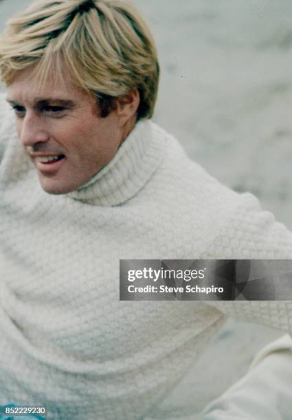 View of American actor Robert Redford, dressed in a white turtleneck, on the set of the film 'The Way We Were' , 1973.