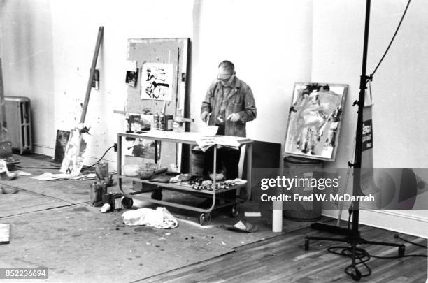 View of Dutch-born American artist Willem de Kooning as he mixes paint in his loft studio , New York, New York, March 23, 1962.