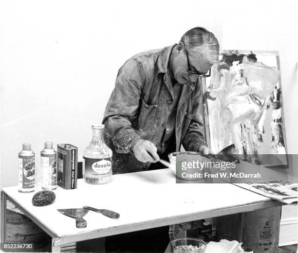 View of Dutch-born American artist Willem de Kooning as he mixes paint in his loft studio , New York, New York, March 23, 1962.