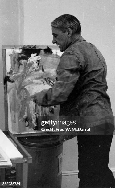 View of Dutch-born American artist Willem de Kooning as he works on a canvas in his loft studio , New York, New York, March 23, 1962.