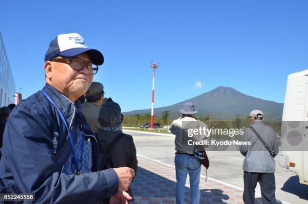 Japanese former residents of a group of Russian-controlled islands off Hokkaido look at a mountain on Etorofu Island on Sept. 23, 2017. ==Kyodo