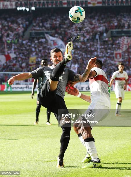 Marcel Heller of Augsburg is challenged by Dennis Aogo of VfB Stuttgart during the Bundesliga match between VfB Stuttgart and FC Augsburg at...