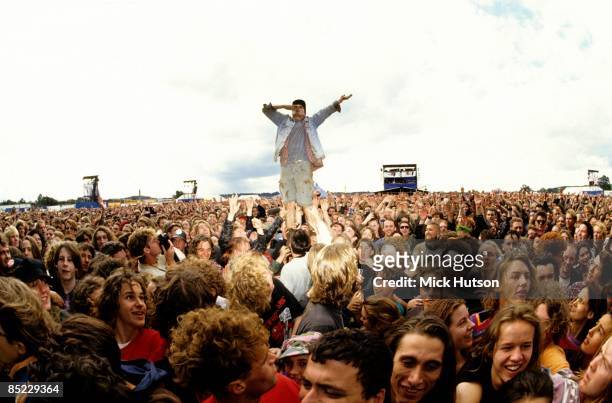 Photo of ROCK FANS and FESTIVALS and FANS and CROWDS, a man stands on the shoulders of someone in the crowd at the Reading Festival